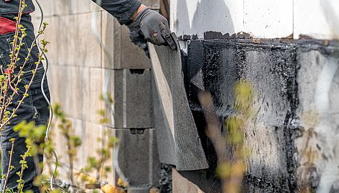 installation of protective waterproofing on the foundation and walls of the building. warmed by an open fire